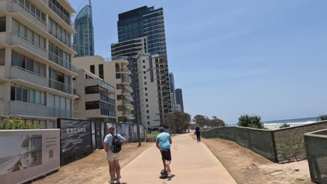 people walking along a coastal urban pathway