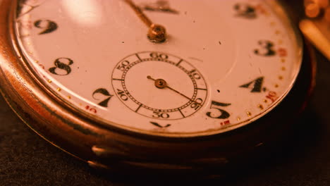 the second hand of a vintage pocket watch is moving under a glass as the camera is moving left to orbit the clock hands