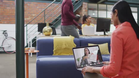 Biracial-businesswoman-using-laptop-for-video-call-with-biracial-business-colleague