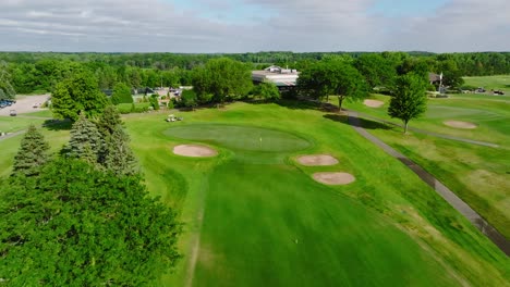 push in drone shot of a golf green with green side bunkers at a golf club