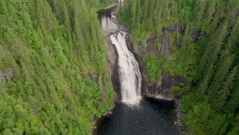 storfossen waterfall with powerful water rushing down rocky cliff, aerial