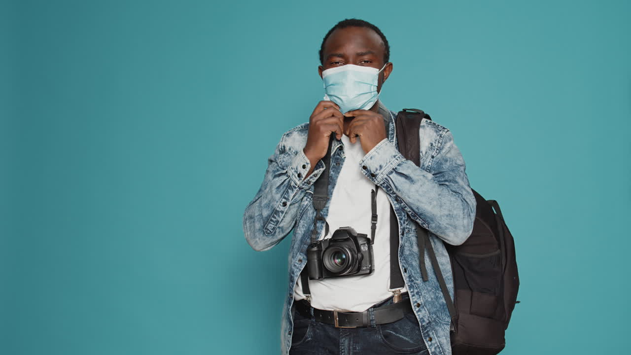 Adult photographer putting face mask on to leave on vacation trip