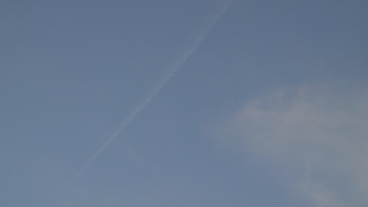 Clear sky with a faint contrail and a hint of clouds, tranquil and serene mood