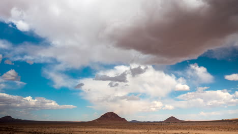 el desierto de mojave, montañas volcánicas extintas y antiguas en forma de cono y un paisaje nuboso dinámico se presentan en este hiperlapso aéreo deslizante