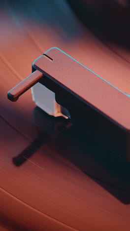 close-up of a record player cartridge on a vinyl record