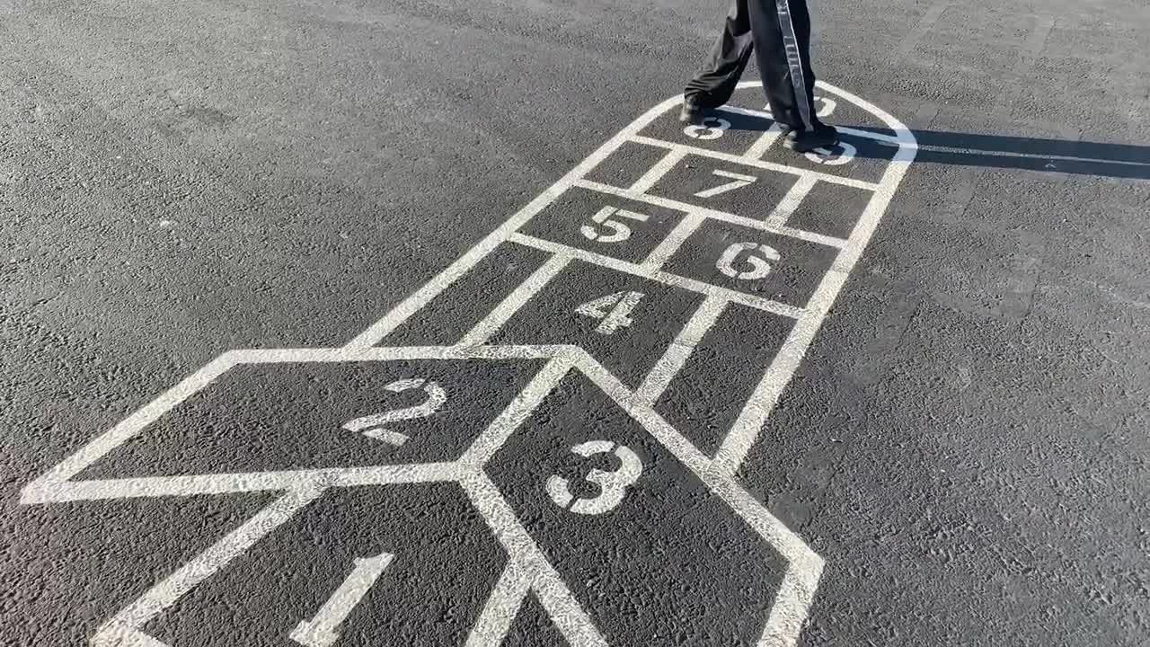 초등학교 아이들에게 인기 있는 야외 활동인 전통 돌차기 놀이를 하는 소년