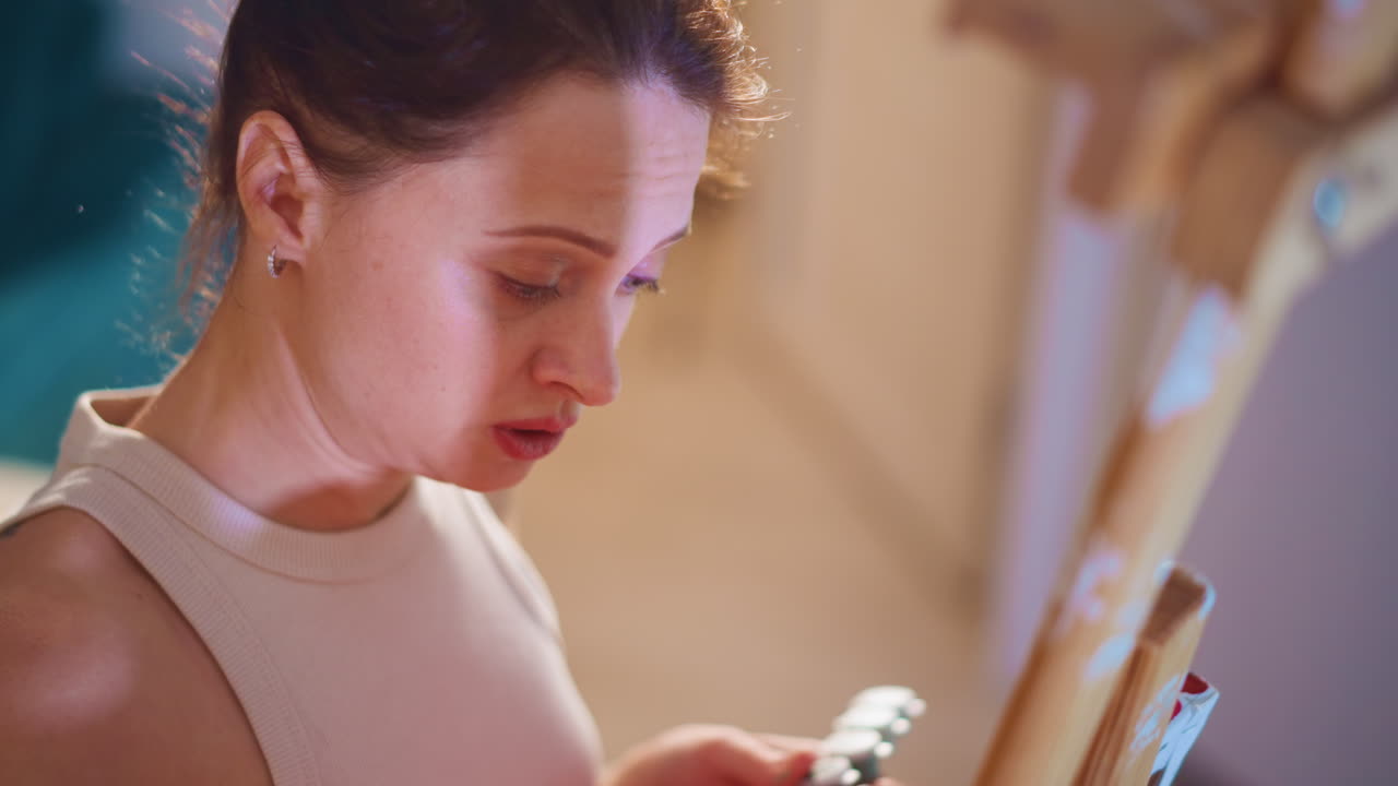 Artist Concentrating Actively, Caucasian Female Artist Mixing Vibrant Colors Attentively, Close View Of Woman Artist Skillfully Blending Bright Pigments On Her Palette With Concentration And Care