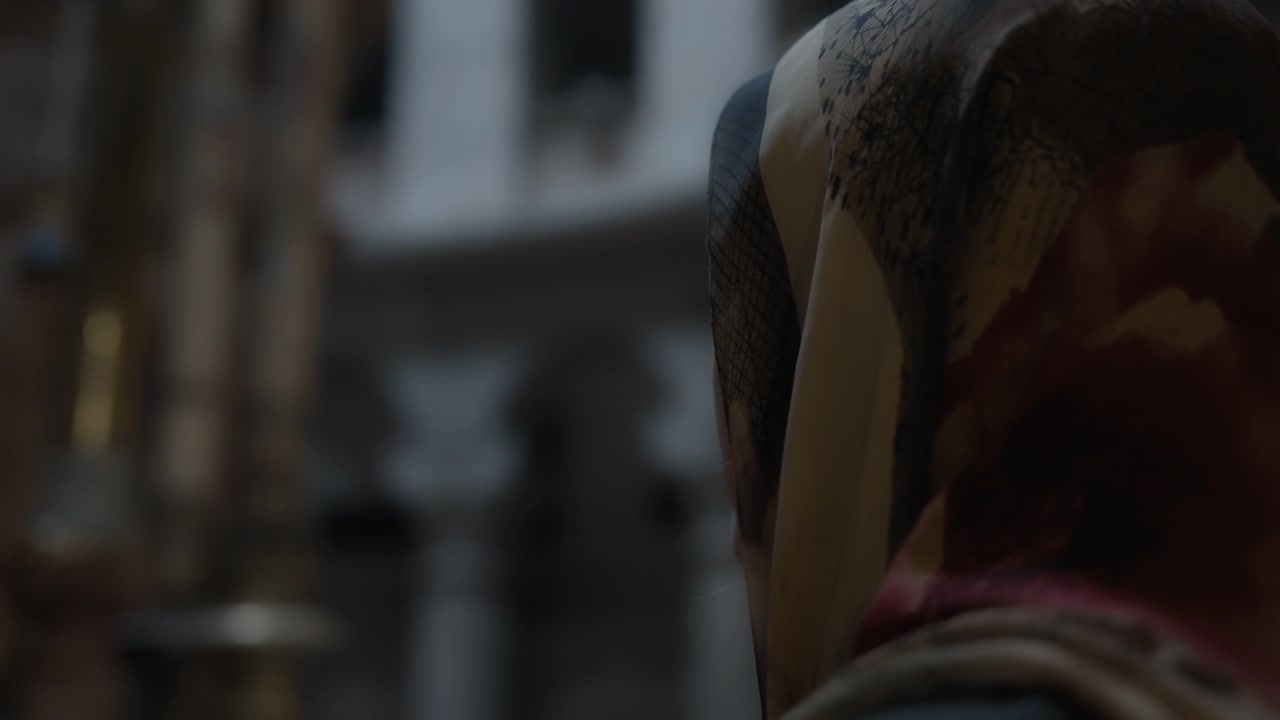 Woman in headscarf praying in church