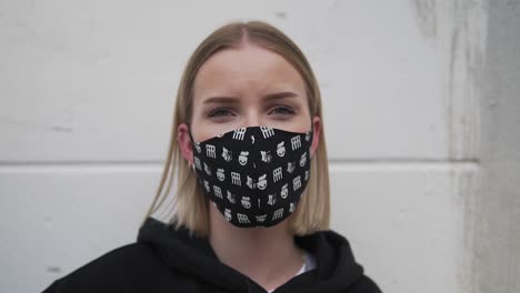 portrait of young woman with face mask looking at camera, close up slow motion