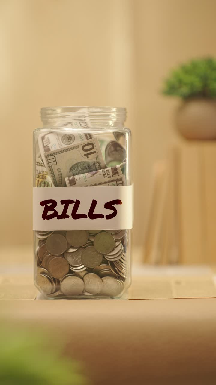 VERTICAL VIDEO OF PERSON SAVING MONEY FOR BILLS