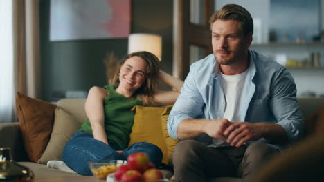 football fan rooting team at evening home sofa. couple watching tv soccer match