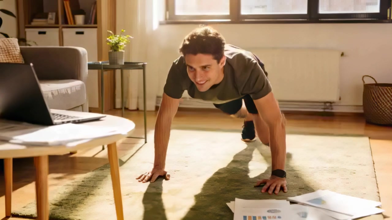 Following laptop workout cue, man wearing olive tee cycling knees on living room rug, with papers