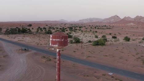 antiguo depósito de agua en medio de la zona montañosa del desierto junto a la carretera asfaltada