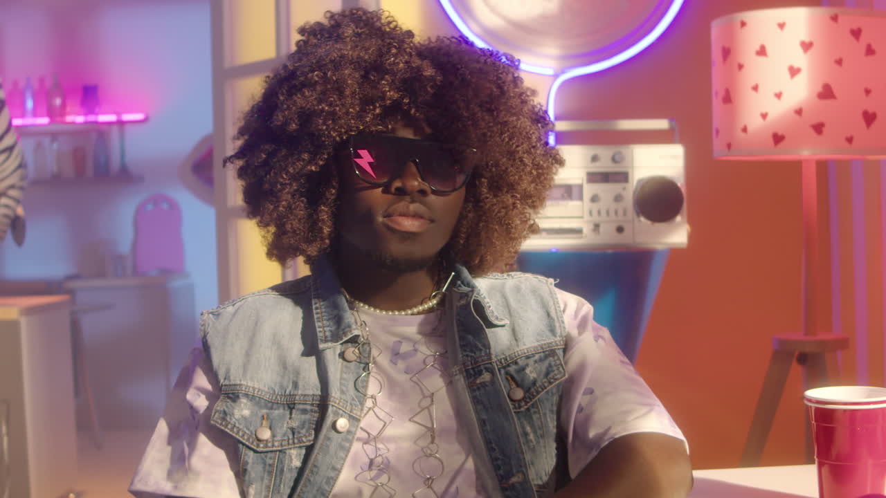 Man in 80s/90s inspired fashion in a colorful retro room