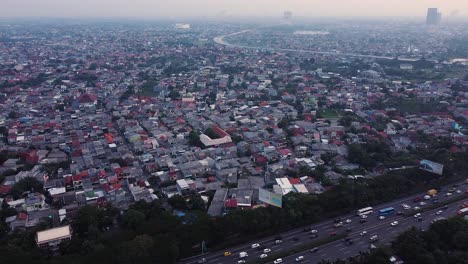 aerial drone shot of a city with densely populated houses and street traffic