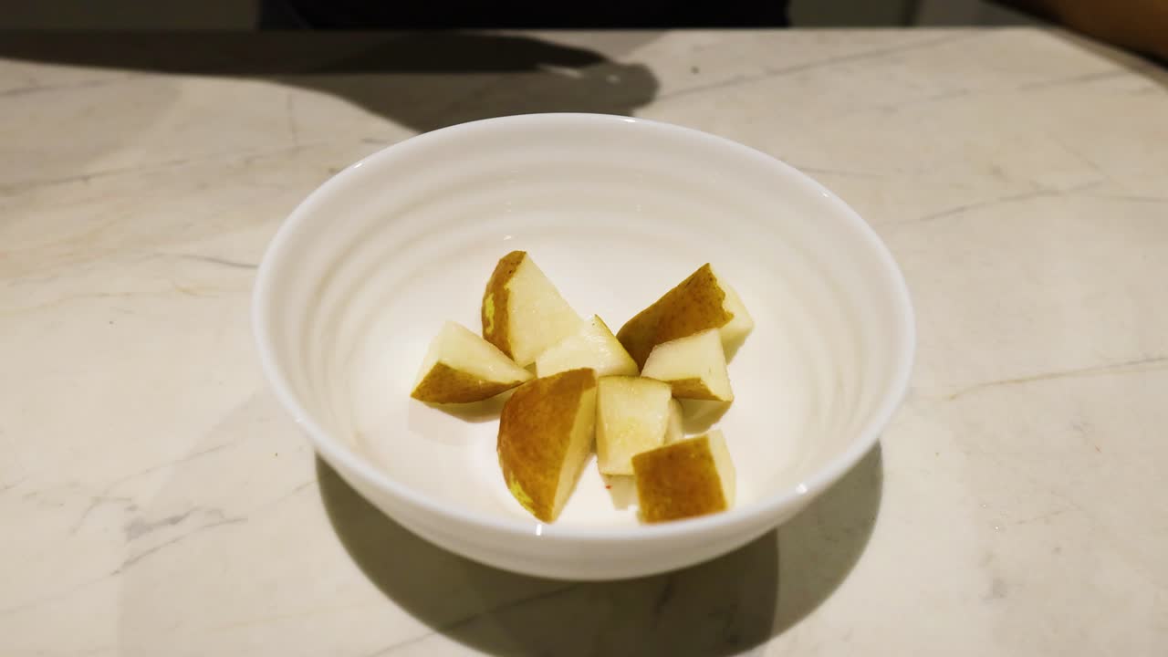 las peras cortadas se dejan caer en un cuenco