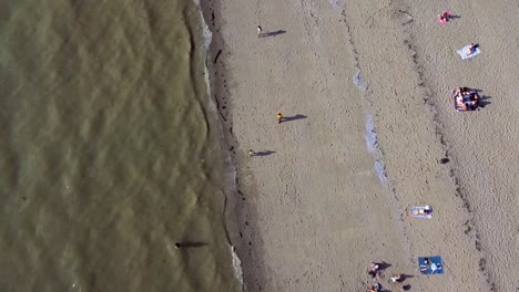 Sobrevuelo-Aéreo-Sobre-Una-Playa-Semiconcurrida-En-Un-Caluroso-Día-De-Verano-Donde-Las-Precauciones-De-Distanciamiento-Social-Pandámico-Se-Toman-Al-Máximo-Respeto