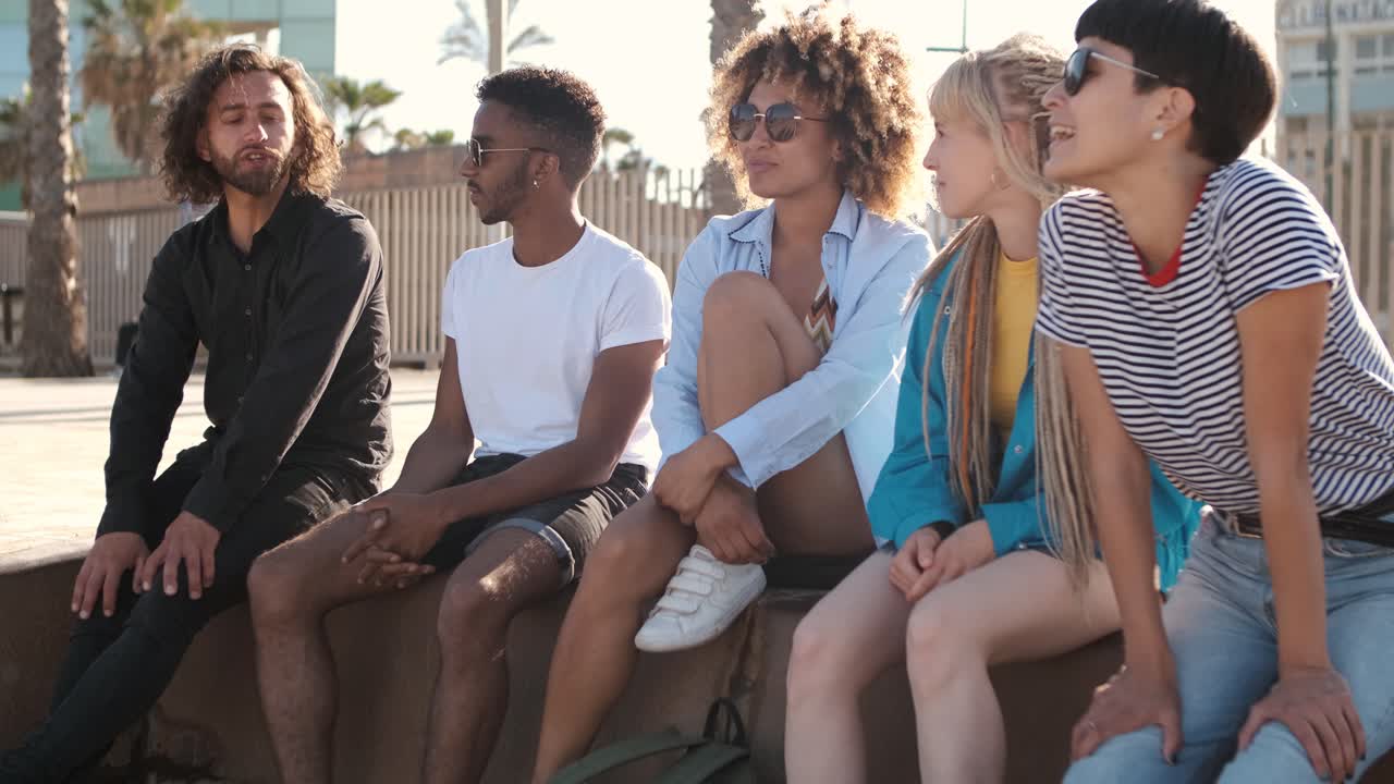 jóvenes amigos contentos relajándose en el paseo marítimo de la ciudad