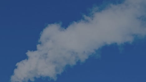 view of smoke coming out of chimney against blue sky. ecology and greenhouse effect concept. sweden.