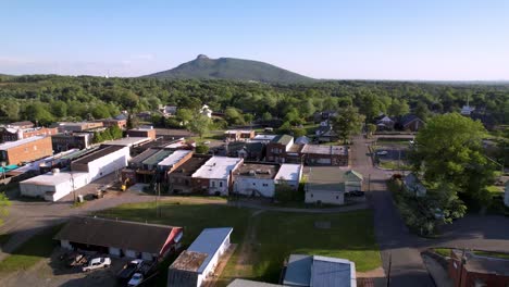 aerial over water tower flying toward pilot mountain and the town of pilot mountain nc, north carolina with pinnacle rock face in the background