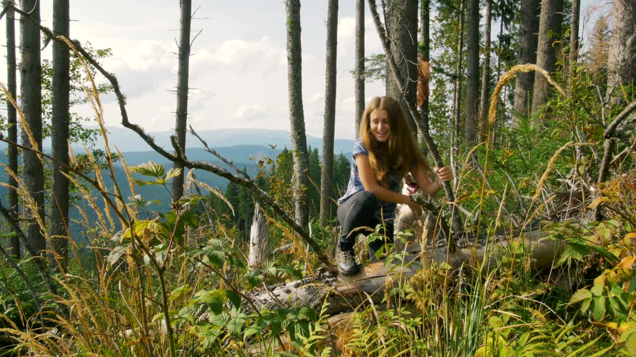 joven jugando con el perro en las montañas