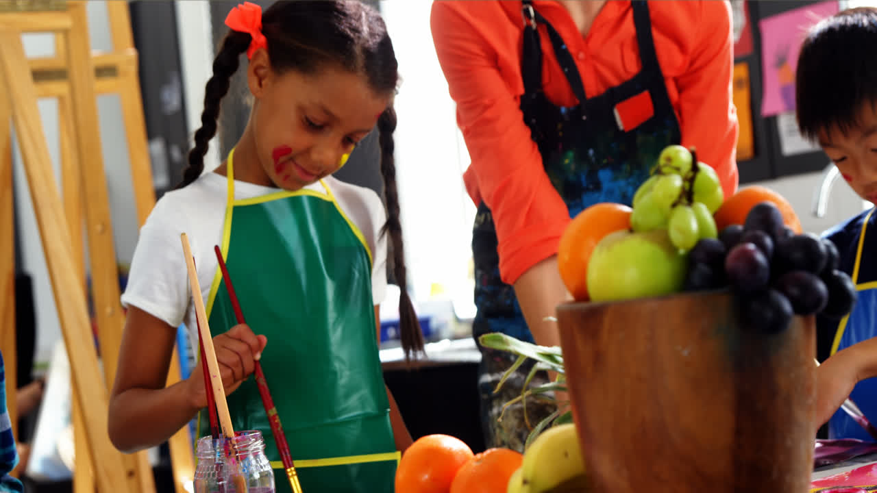 maestro ayudando a un escolar en la clase de dibujo