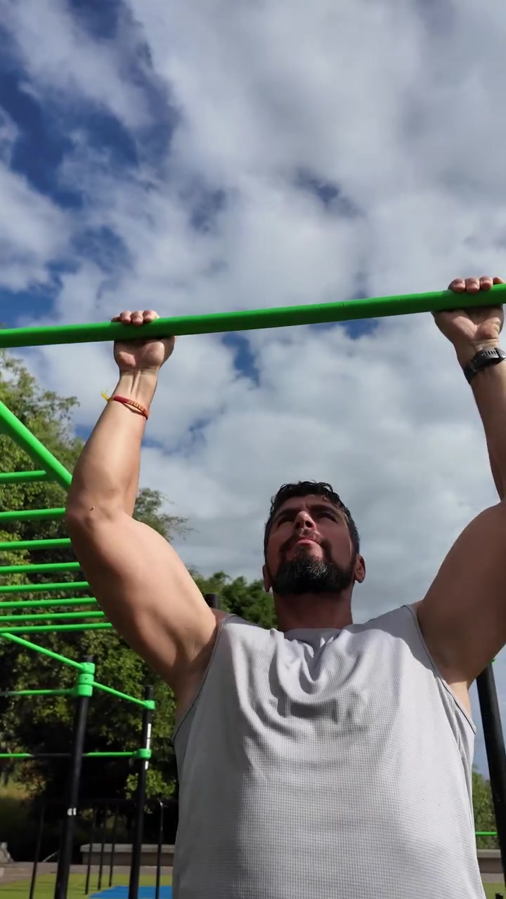 Muscular Man Performing Pull-Ups on Outdoor Calisthenics Equipment