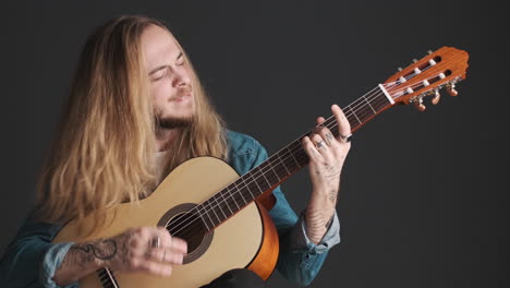 excited caucasian young man playing guitar on camera.