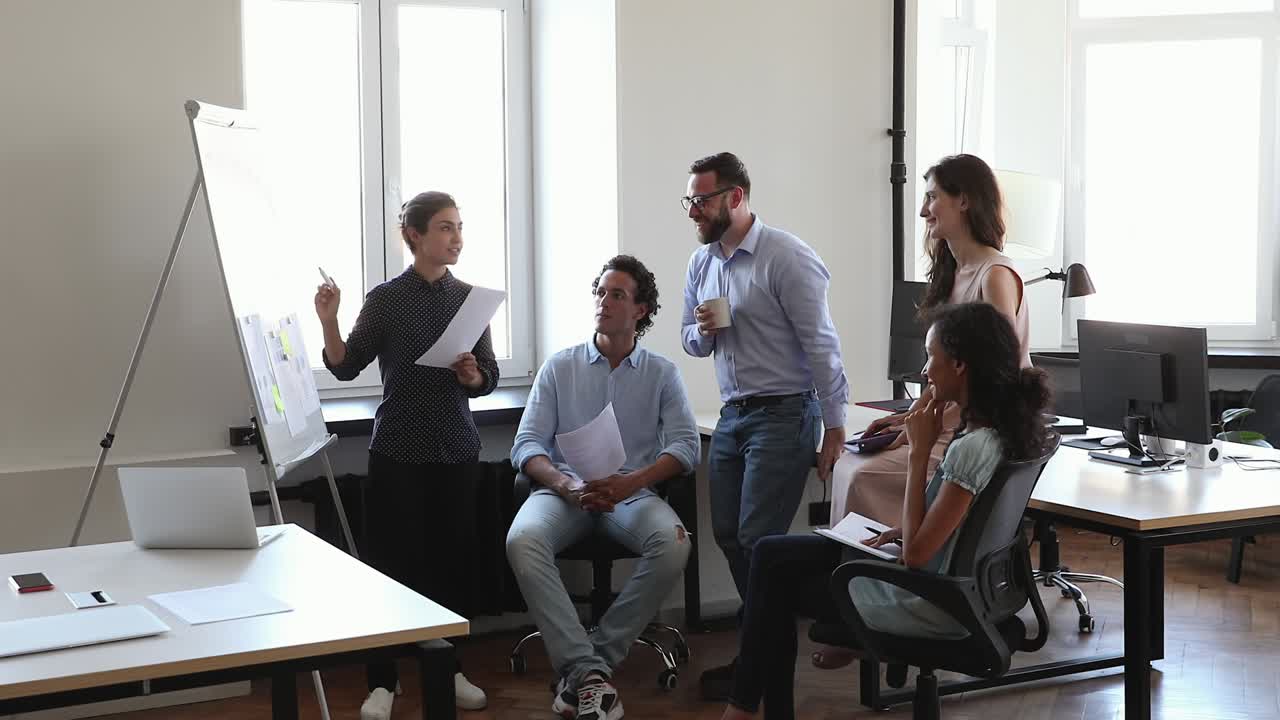 una joven empresaria india usa flip chart para hacer una presentación para sus colegas.