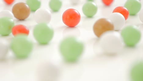 colorful bonbons arranged on white reflective background 4k