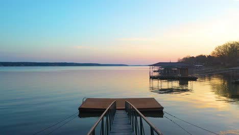 moviéndose a través de un dique flotante de madera y un puente a orillas del lago del gran lago o' the cherokees en el medio oeste de oklahoma al atardecer