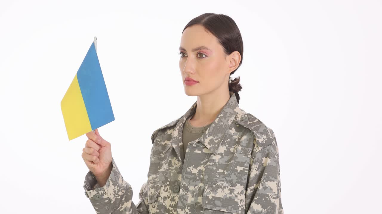 Woman in military uniform holding Ukrainian flag