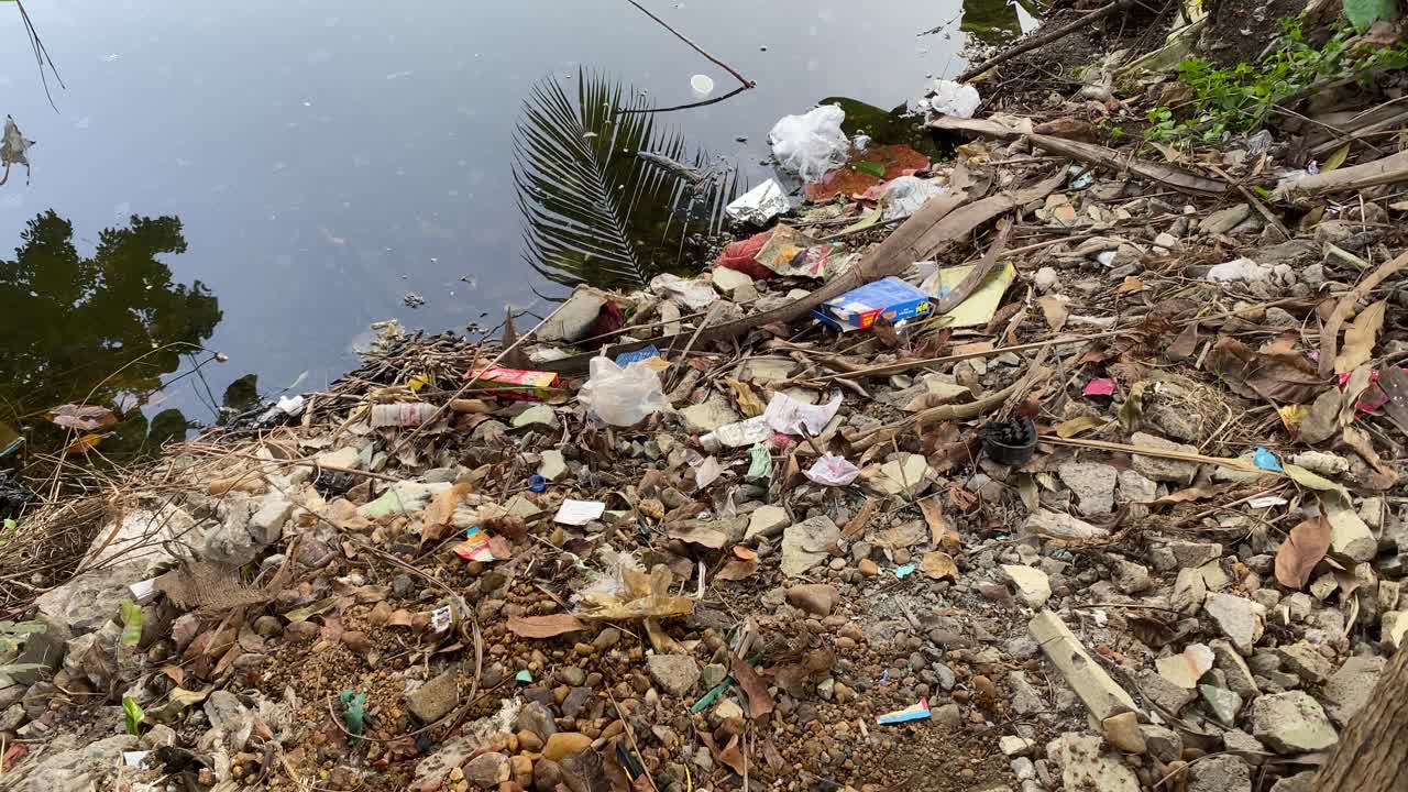 Plastic waste near a beautiful building in Kolkata with reflection in water