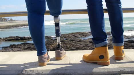 sección baja de una pareja de pie en el paseo cerca de las barandillas 4k