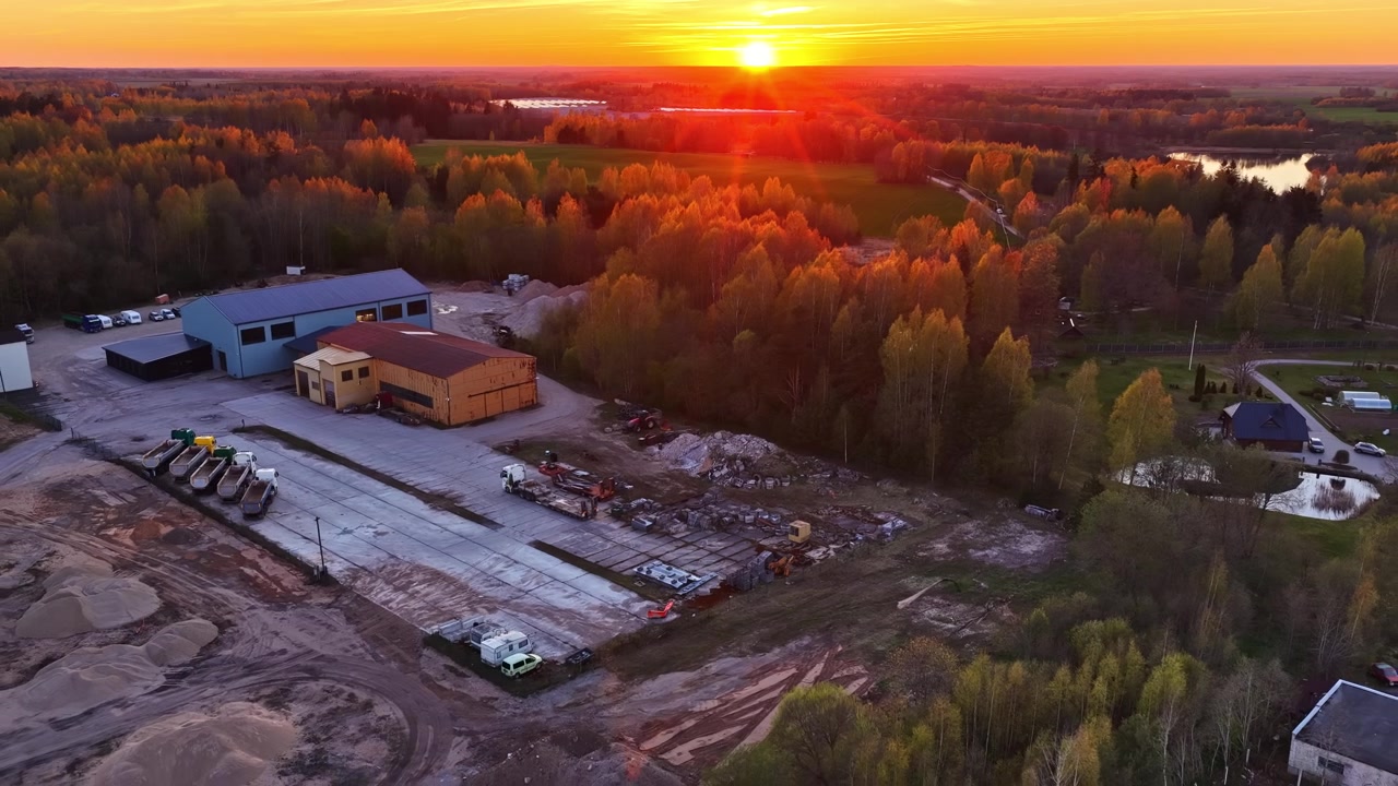 Landligt industriområde under en smuk og farverig solnedgang i malerisk luftfoto.