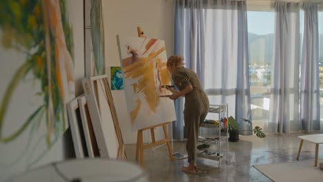 mujer artista pintando en su estudio