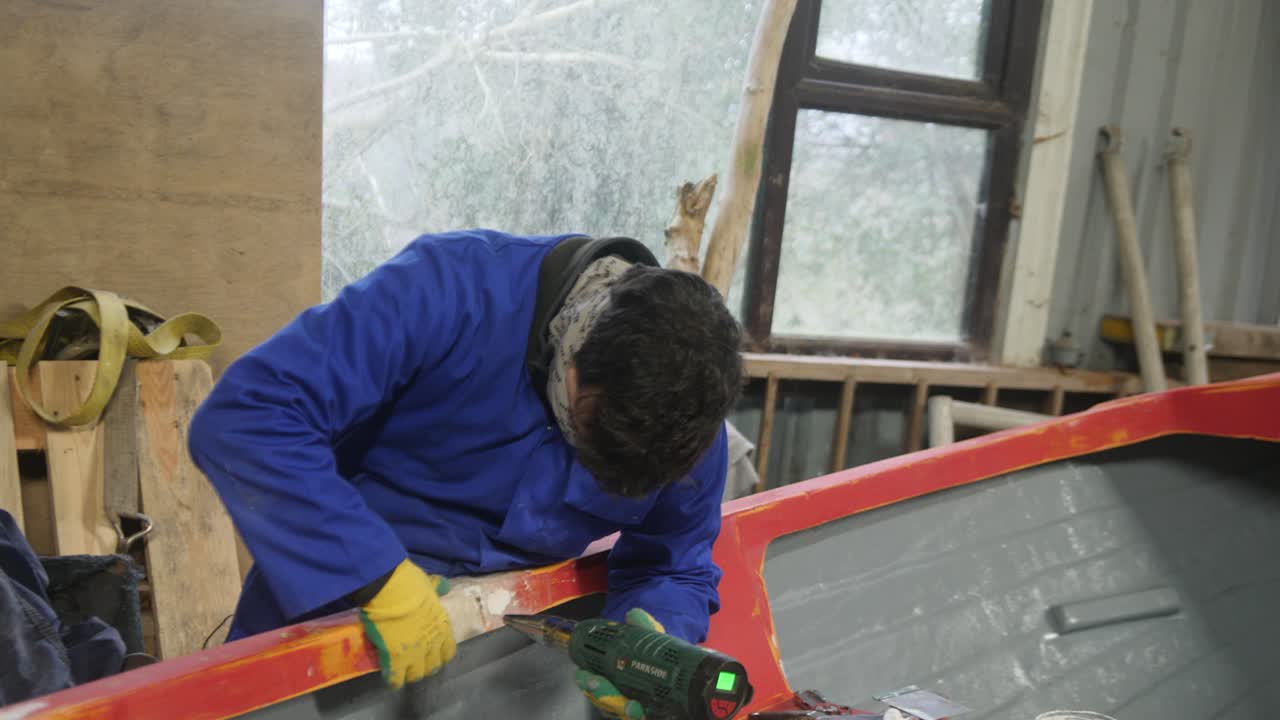 Uso della pistola termica per far indurire lo stucco sulla riparazione di una barca in vetroresina