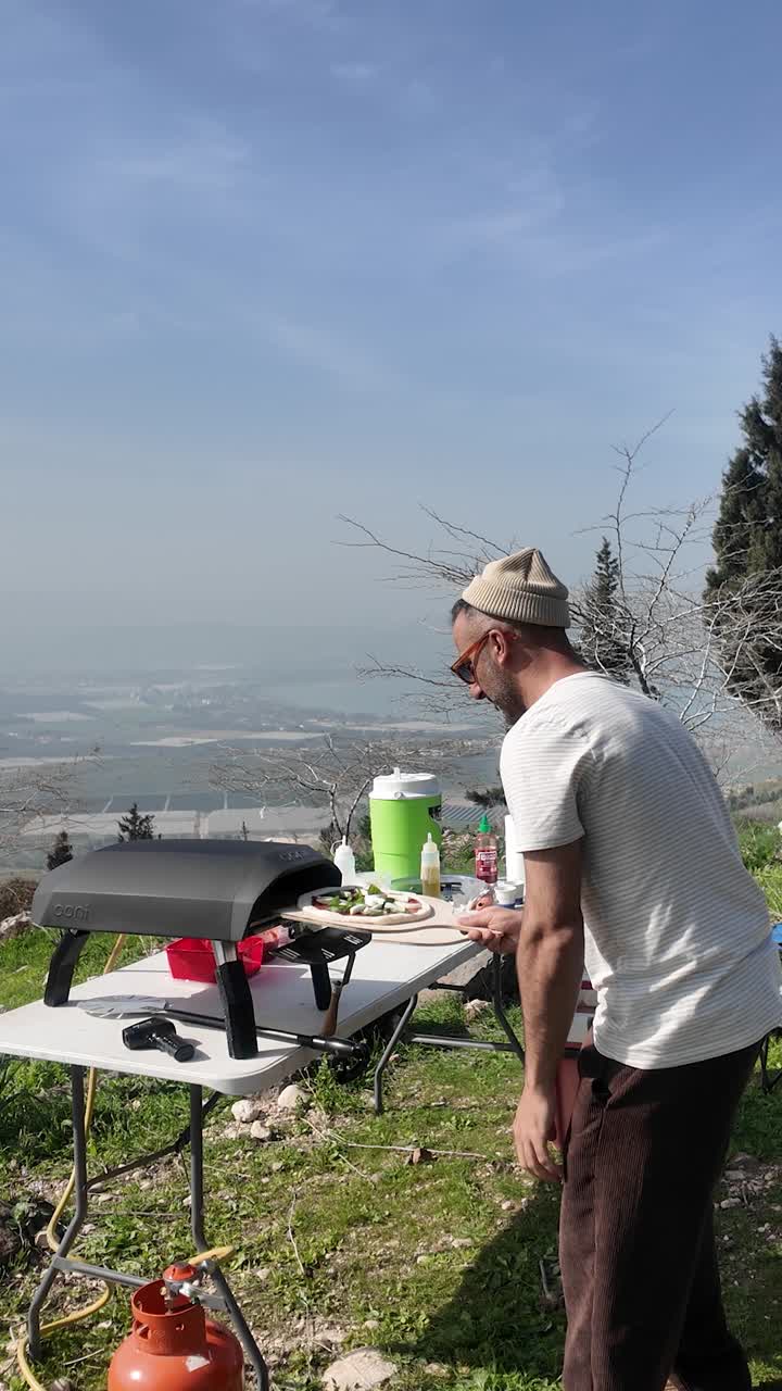 La classica pizza Margherita viene infornata in un forno a gas da uno chef che lavora da una postazione elegante in montagna.