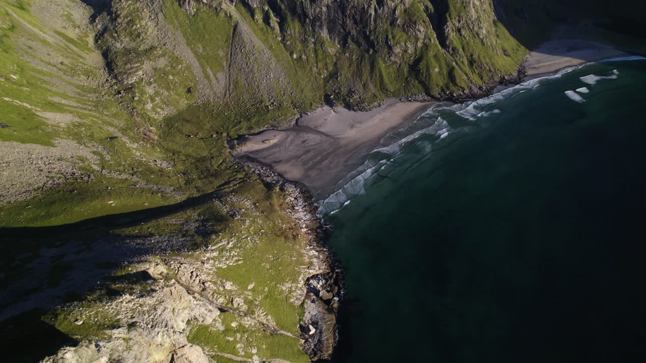 toma cinematográfica desde lo alto de la colina hacia la impresionante y tranquila playa de kvalvika