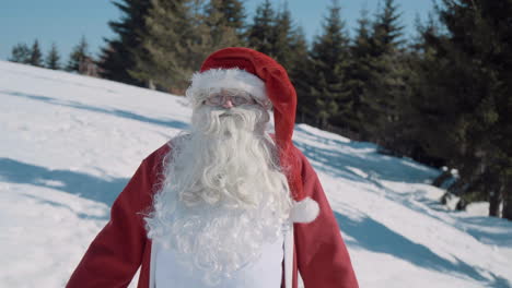 santa camina hacia la cámara a través de un campo nevado