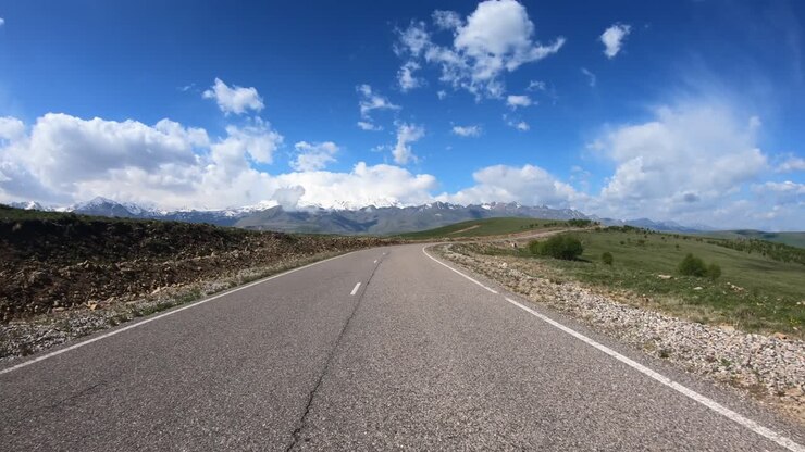 Guida di un'auto su strada (punto di vista). Il Monte Elbrus è visibile sullo sfondo.