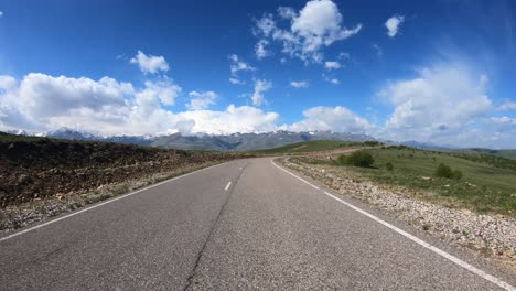 punto de vista conduciendo un coche en una carretera. el monte elbrus es visible en el fondo.