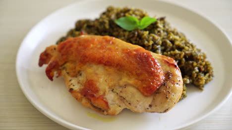 arroz frito al pesto con pollo asado en plato blanco