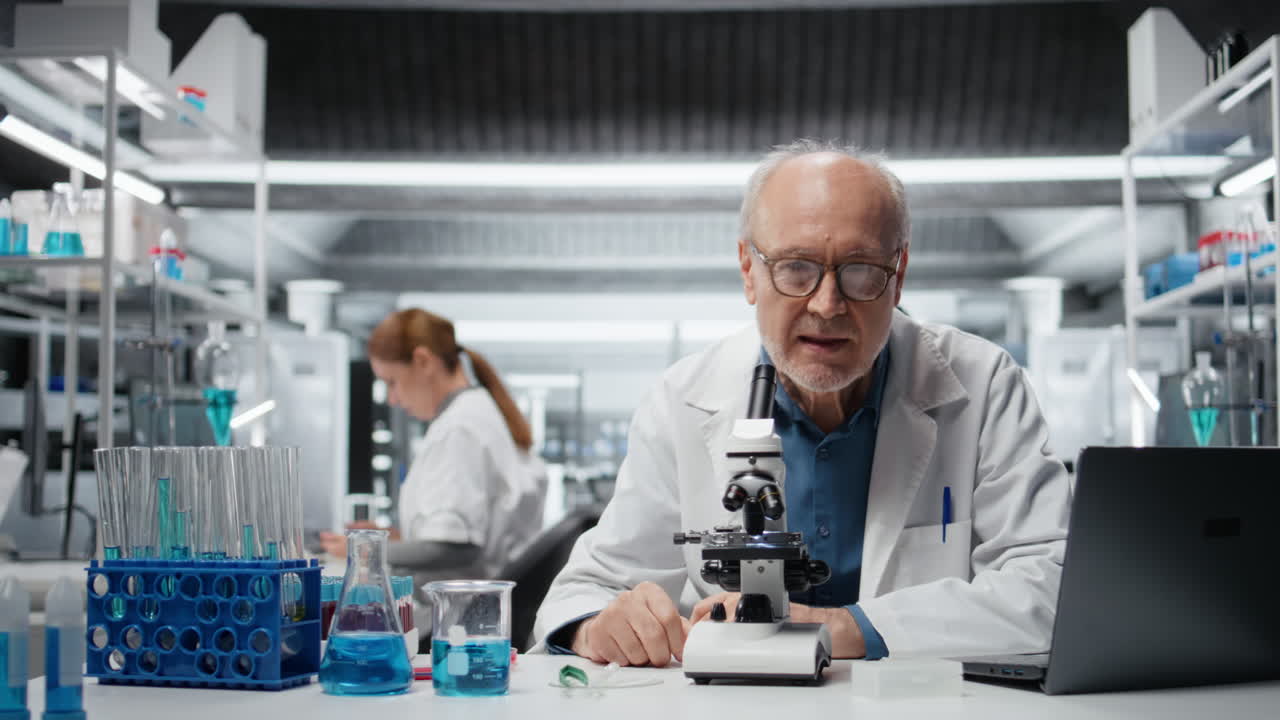 Portrait of jolly researcher analyzing genetic sample with microscopic equipment