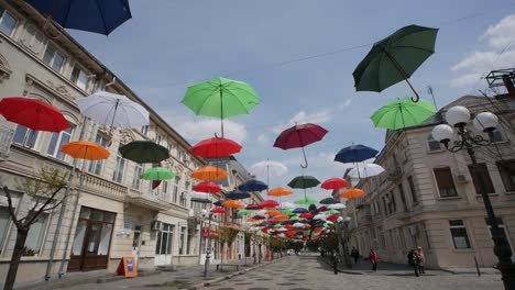 braila, romania. april 24 2019 the old central part. cobbled street. ancient architecture and multicolored umbrellas hanging in the air. artistic atmosphere.