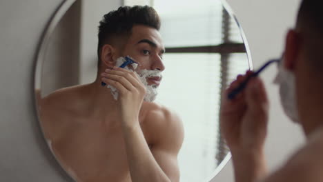 hombre afeitándose en el baño