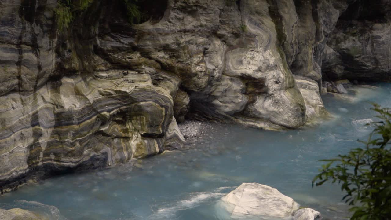 a blue river flows in a cliff valley with green leaves. A mountain river in Taroko national park
