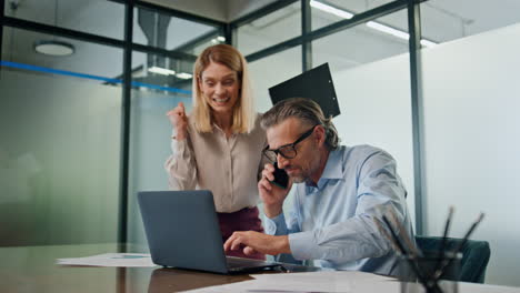 Excited-partners-celebrating-victory-in-office.-Successful-coworkers-achievement