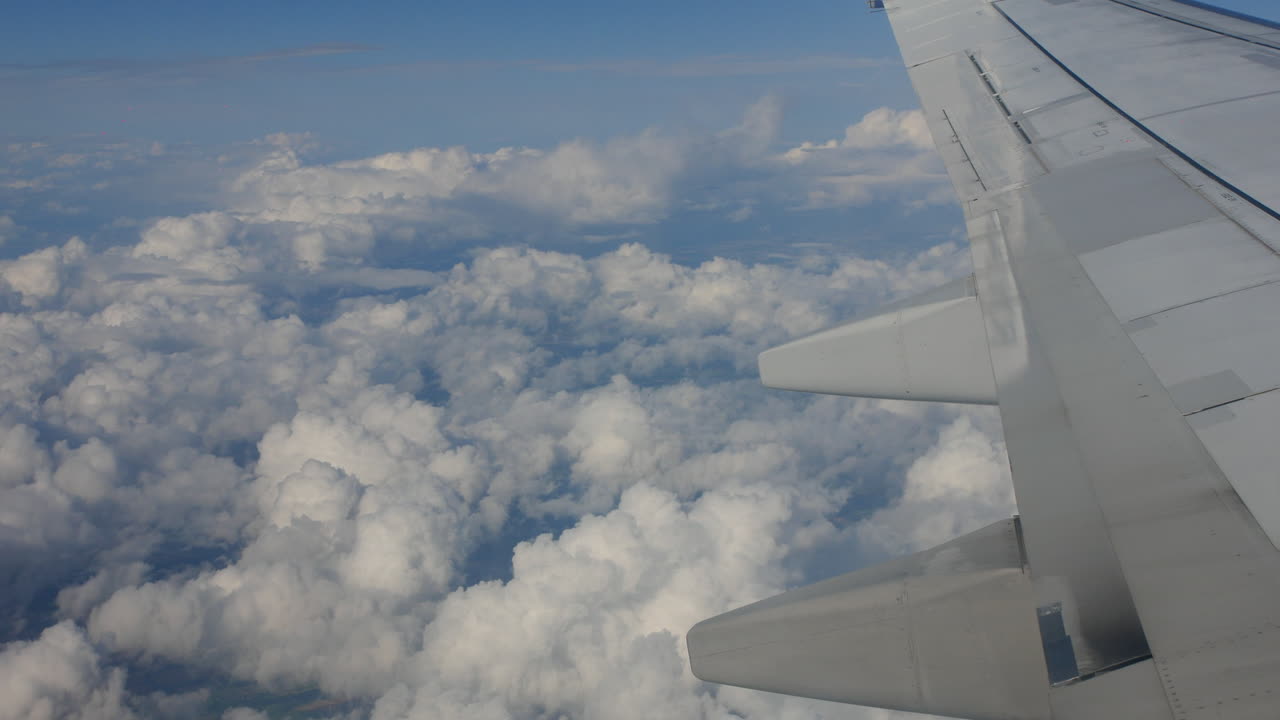 volando por encima de las nubes con un ala de avión en el cielo desde la ventana por encima del ala de un avión de pasajeros