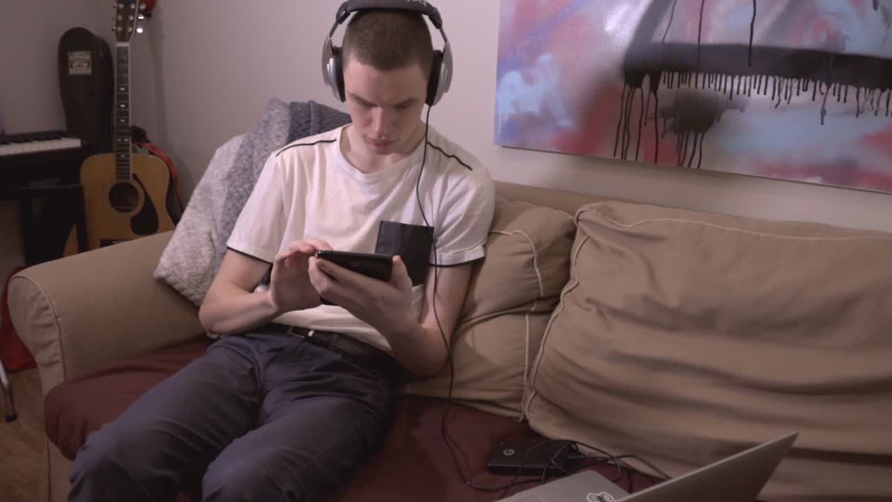 apuesto hombre de negocios desplazándose en su tableta digital y escuchando música